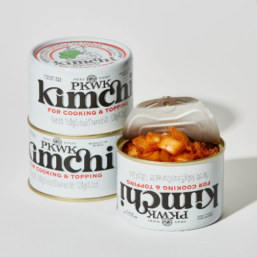 Three cans of Picky Wicky kimchi. One can is partially open, showing the kimchi inside.